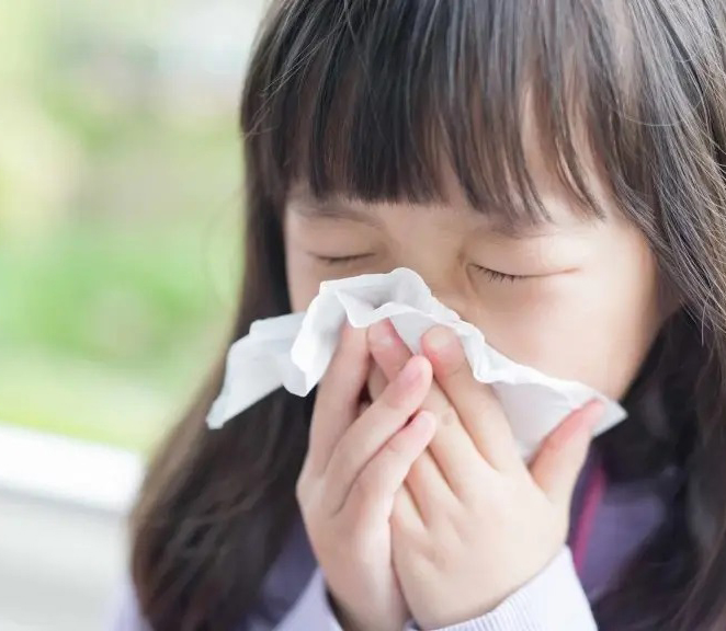 Little girl blowing her nose